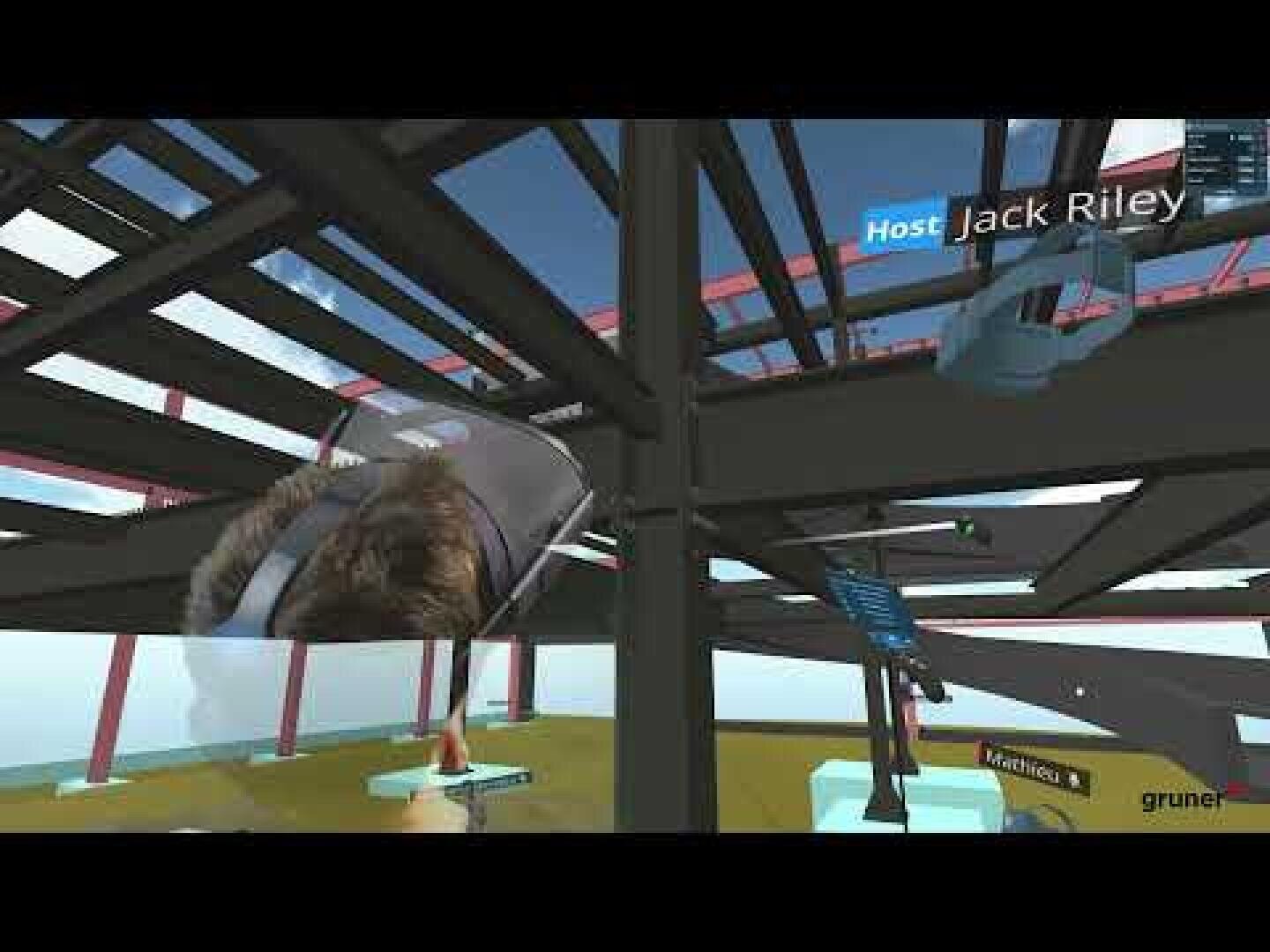 Eine Virtual-Reality-Umgebung, die eine Gebäudestruktur aus Stahl mit schwebenden Benutzeroberflächen zeigt. Der Name Jack Riley erscheint über einem Helm und einem gespiegelten Gesicht, das auf den Gastgeber hinweist. Ein blauer Himmel und ein grasbewachsener Boden sind zu sehen.