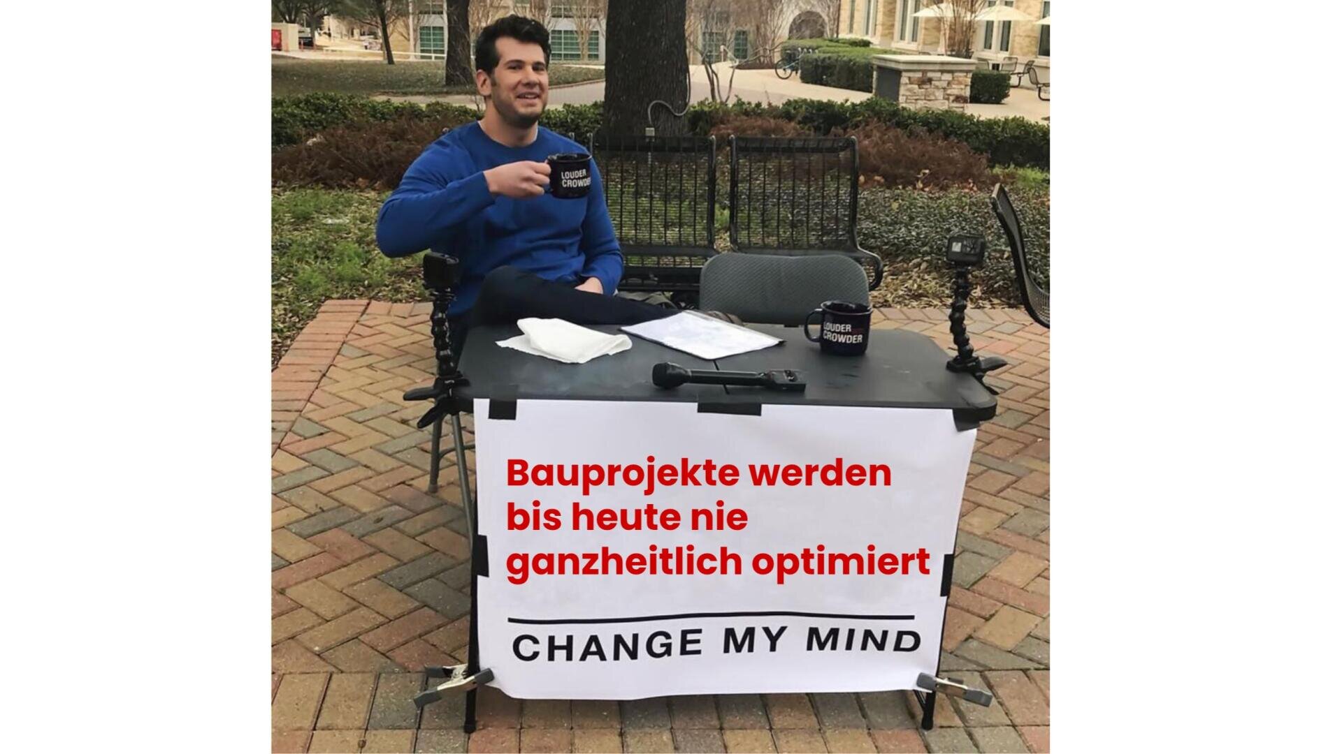 Ein Mann sitzt an einem Tisch im Freien mit einem Schild, auf dem steht: Bauprojekte werden bis heute nie ganzheitlich optimiert. MEINE MEINUNG ÄNDERN. Er hält einen Becher und schaut in die Kamera.