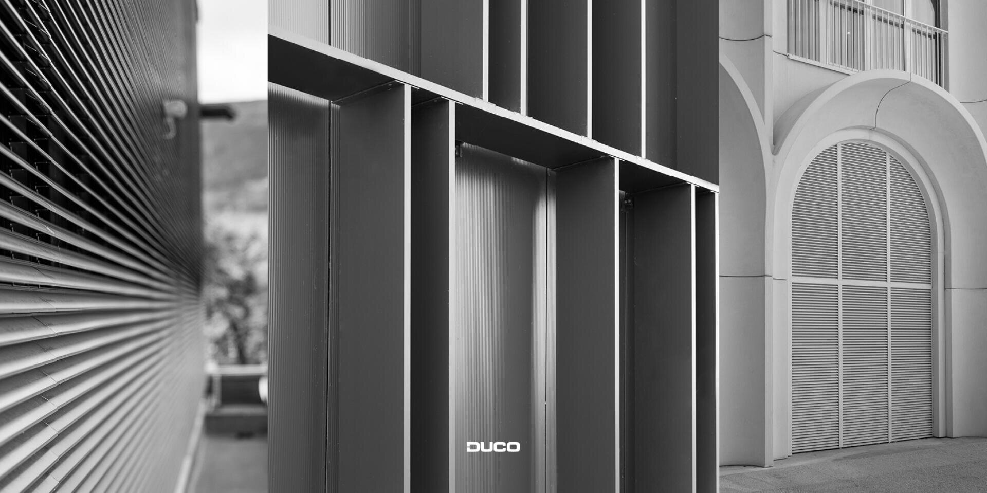 Eine Schwarz-Weiß-Collage von drei architektonischen Details: horizontale Metalllamellen links, vertikale und horizontale Gitter in der Mitte und große bogenförmige Metallgitter an einer Gebäudefassade rechts. DUCO ist unten in der Mitte zu sehen.
