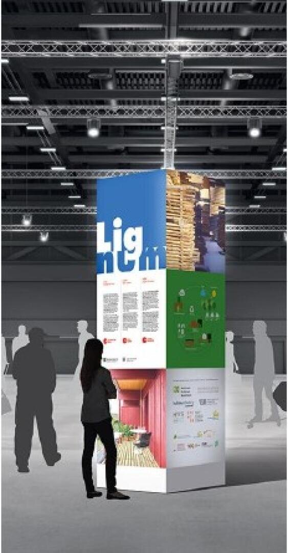 Une personne se tient devant un haut présentoir rectangulaire avec des panneaux colorés et du texte, situé dans une grande salle d'exposition couverte avec un puits de lumière et d'autres figures silhouettées à proximité.