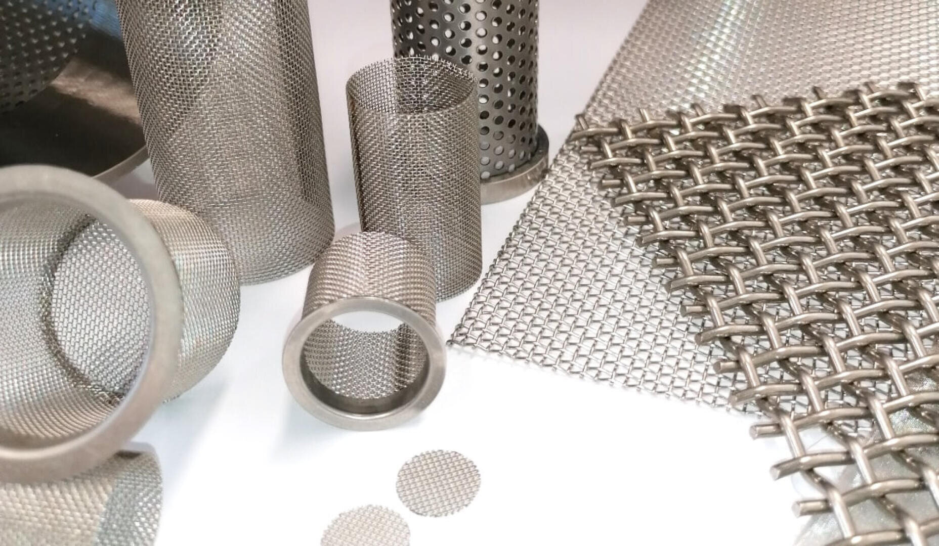 Plusieurs types et formes de mailles et de filtres métalliques, y compris des formes cylindriques et des feuilles plates, sont présentés sur une surface blanche, mettant en valeur leurs motifs complexes et leurs styles de tissage.
