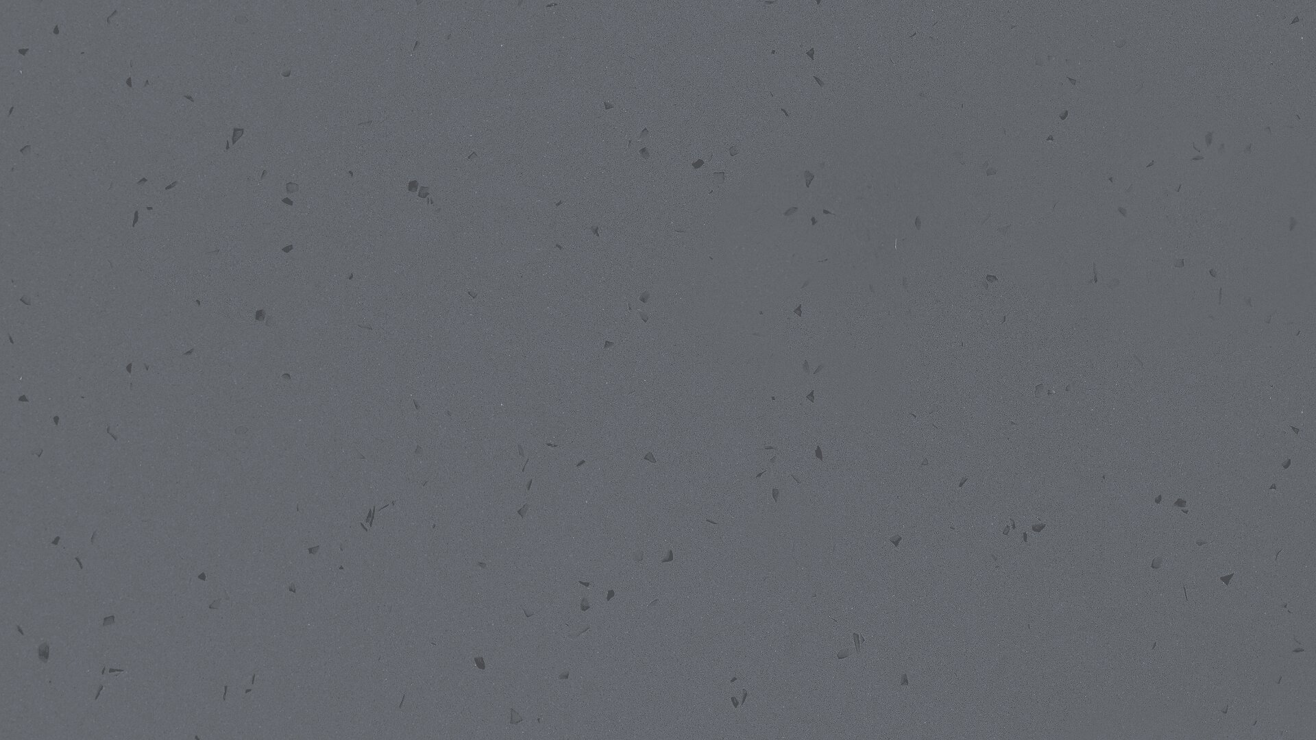 Nahansicht einer glatten, grauen Oberfläche, die mit kleinen schwarzen Flecken und unregelmäßigen Markierungen übersät ist.