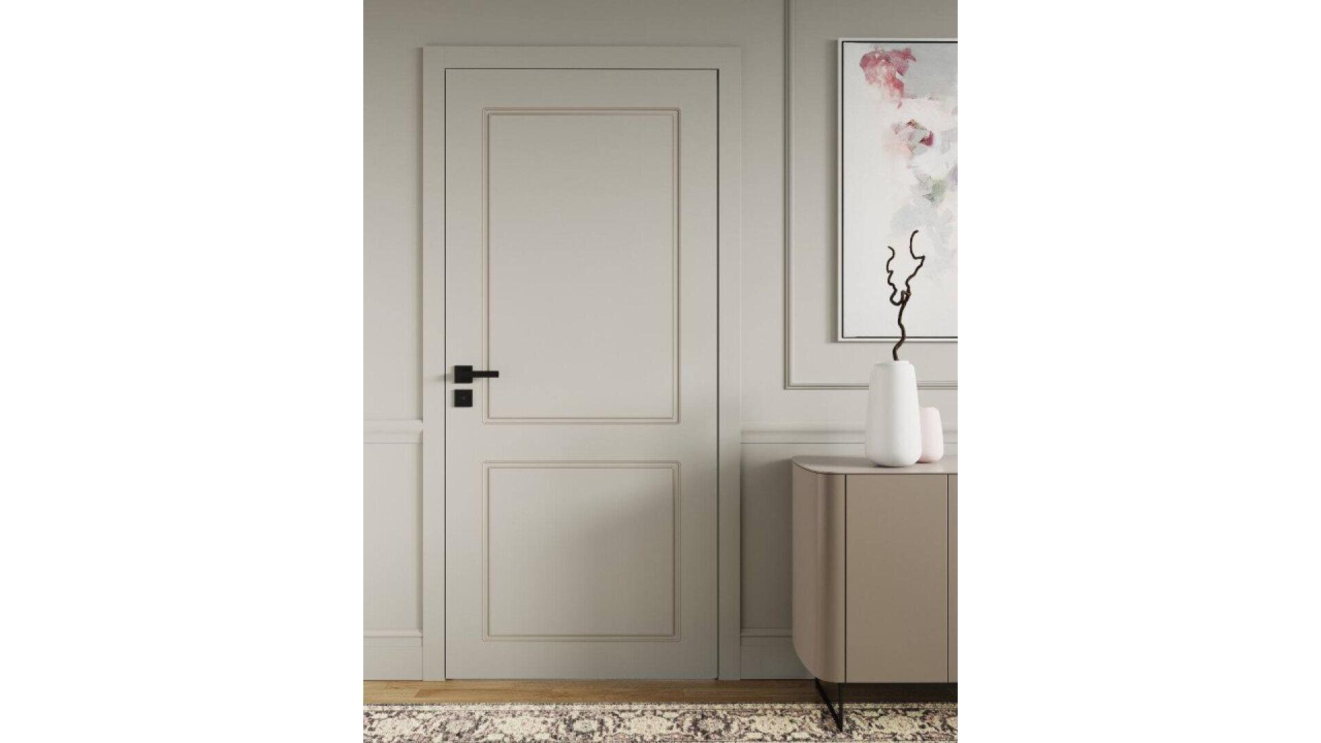Une porte beige fermée avec une poignée noire, encastrée dans un mur clair. À droite, une peinture abstraite encadrée est suspendue au-dessus d'un meuble beige avec deux vases blancs et une branche décorative noire. Un tapis à motifs est posé sur le sol.