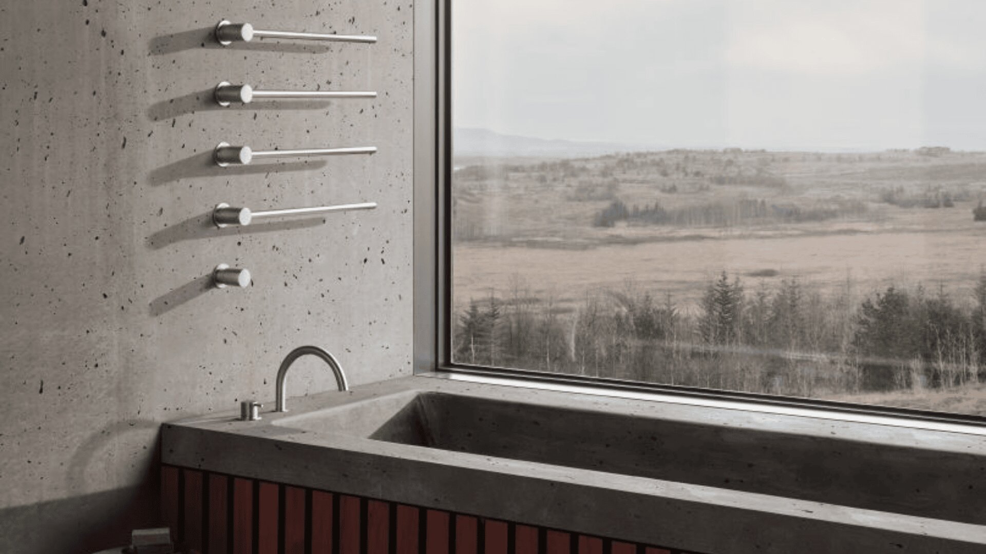 Ein modernes Badezimmer mit einer Badewanne aus Beton, minimalistischen silbernen Armaturen an der Wand und einem großen Fenster mit Blick auf eine weite, grasbewachsene Landschaft mit vereinzelten Bäumen und einem bewölkten Himmel.