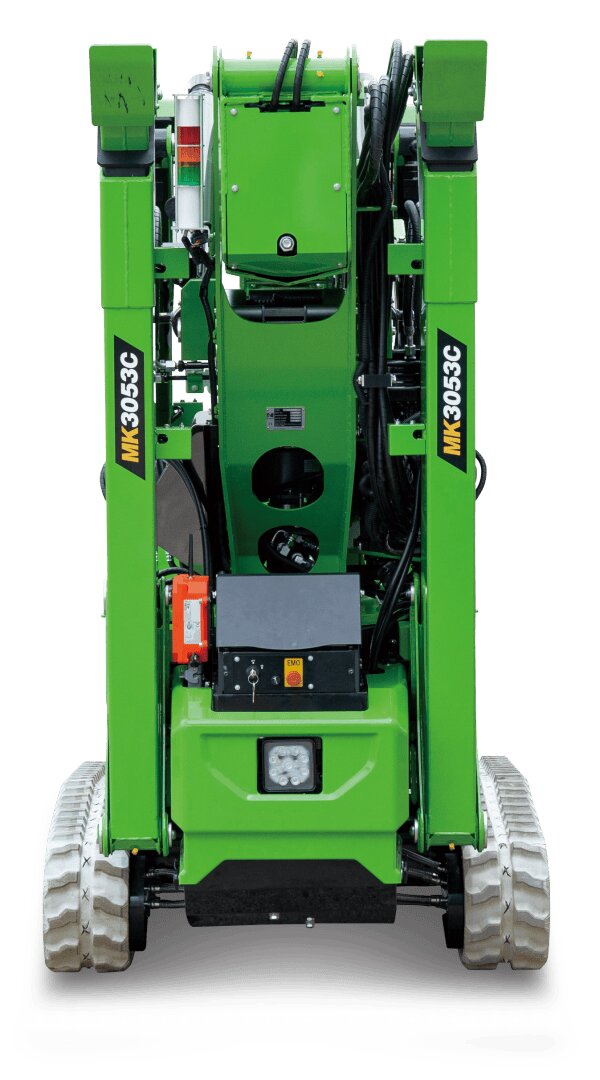 Vorderansicht einer grünen kompakten Baumaschine mit Raupenfahrwerk, beschriftet mit MK 305 GC. Zu sehen sind verschiedene Kabel, ein Schaltkasten und mechanische Komponenten. Der Hintergrund ist einfarbig weiß.