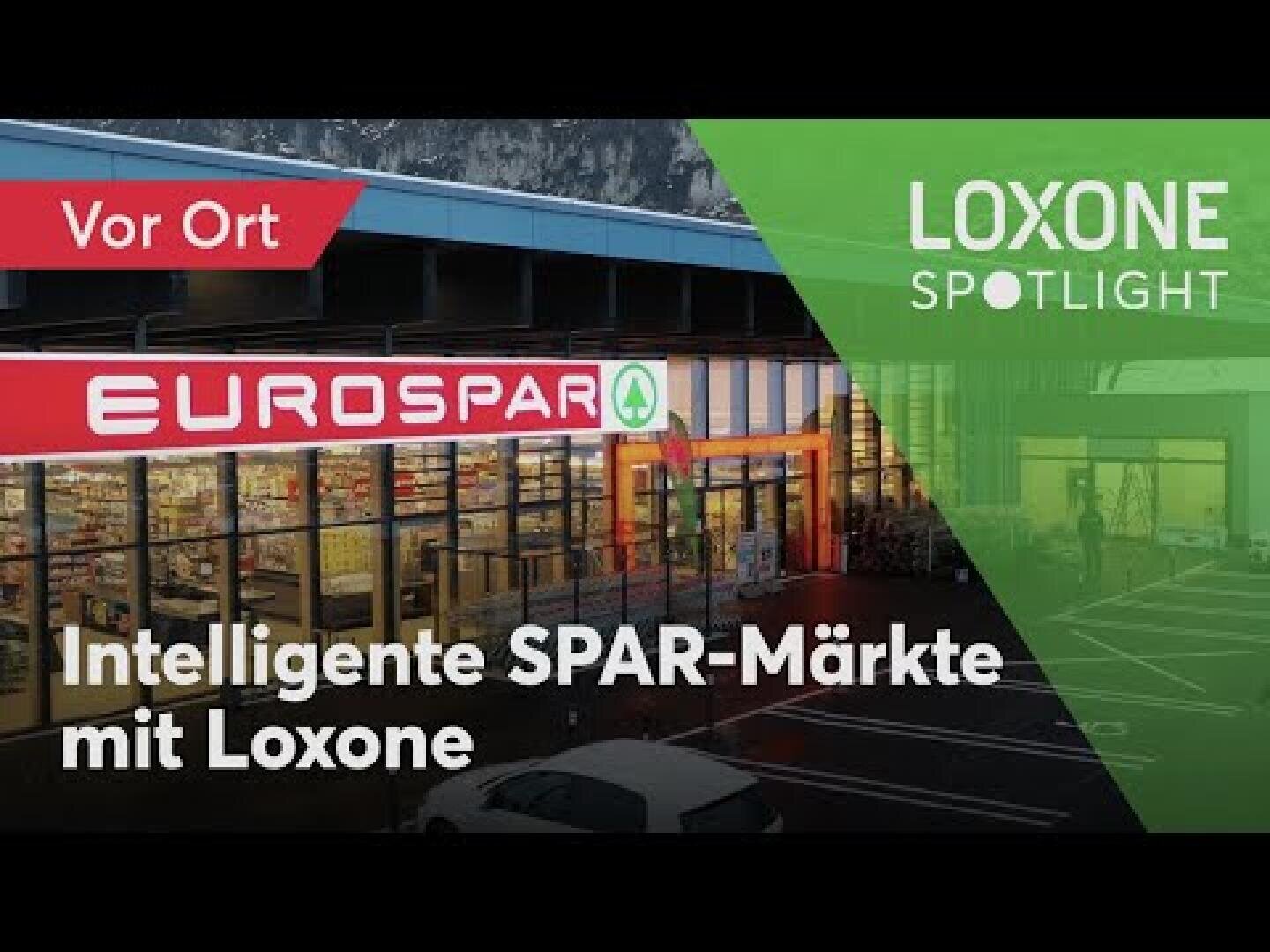 Außenansicht eines EUROSPAR-Supermarktes mit Textüberlagerung in Deutsch: Intelligente SPAR-Märkte mit Loxone. Das Loxone Spotlight-Logo und Vor Ort sind ebenfalls sichtbar.