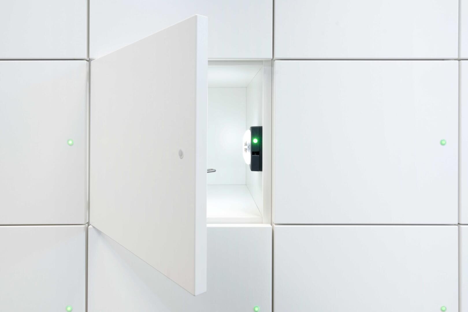 Ein weißer Schrank mit einer geöffneten Tür, die ein helles, leeres Fach im Inneren freigibt. Der Schrank hat ein klares, minimalistisches Design mit kleinen grünen Kontrollleuchten an den geschlossenen Türen.
