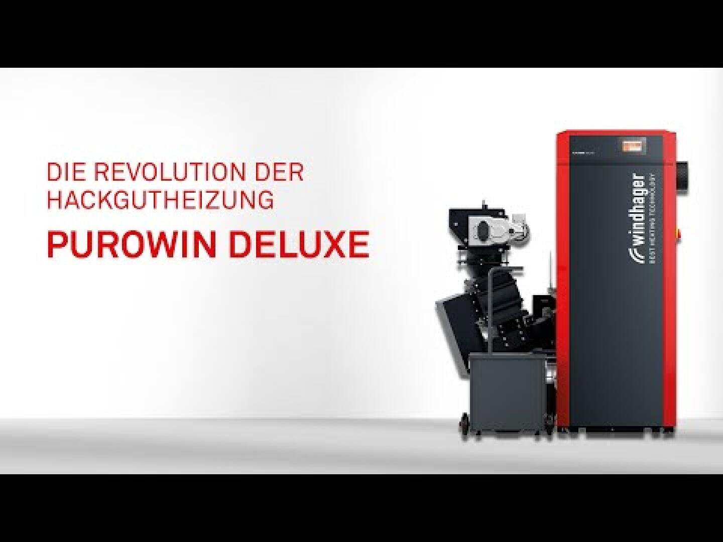 Ein rot-schwarzes Windhager Heizsystem mit der Aufschrift PUROWIN DELUXE steht neben seinen Komponenten auf weißem Hintergrund. Der deutsche Text lautet: Die Revolution der Hackgutheizung PUROWIN DELUXE.